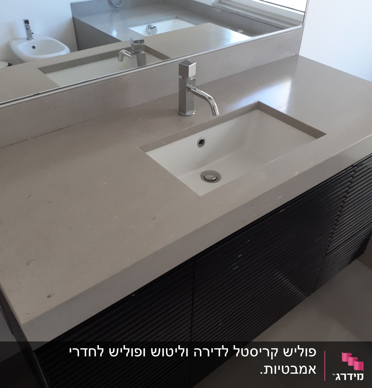 כיור נקי עם ברז כסוף במשטח אמבטיה